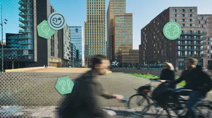 Personnes à vélo devant des immeubles modernes aux Pays Bas