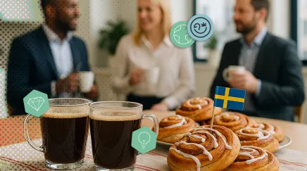 Deux tasses de café et des cinnamon buns suédois avec un drapeau suédois sur une table.
