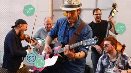 Groupe de musiciens de rue jouant de la guitare, violon et contrebasse avec énergie.