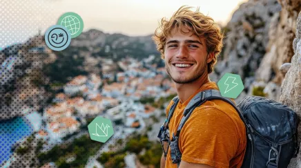 Jeune homme souriant en randonnée, en haut d’un point de vue côtier ensoleillé