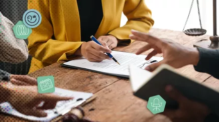 Discussion professionnelle autour d’un contrat sur table en bois, symboles juridiques visibles