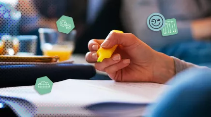 Main tenant un surligneur jaune en train de surligner du texte sur un document de réunion