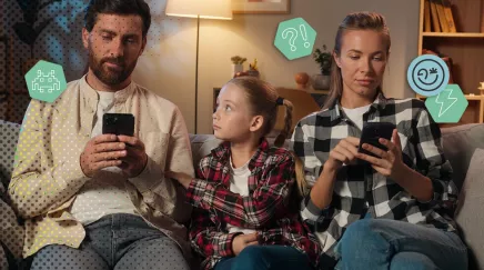 Un enfant observe son parent absorbé par l’écran de son smartphone.