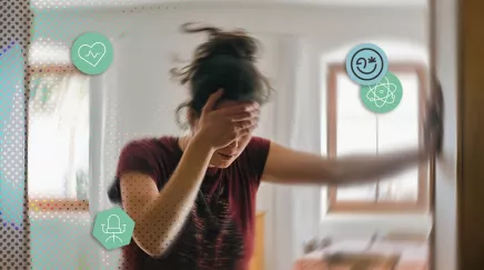 Femme floue se tenant à un mur, la main sur le front, symbolisant le stress