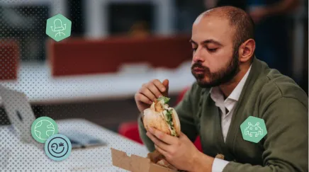 Un homme mange un sandwich au bureau
