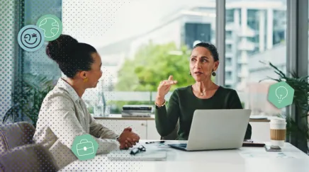 Une manageuse échange avec sa collaborateur autour d'un bureau