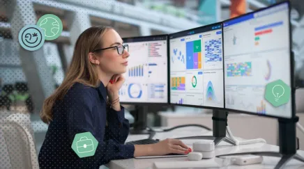 Une femme regarde de nombreux KPI sur ses écrans d'ordinateur