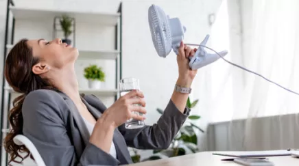 Femme qui se ventile durant la canicule au bureau 