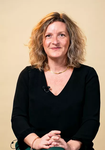 L'intervenante est assise sur une chaise en regardant la caméra