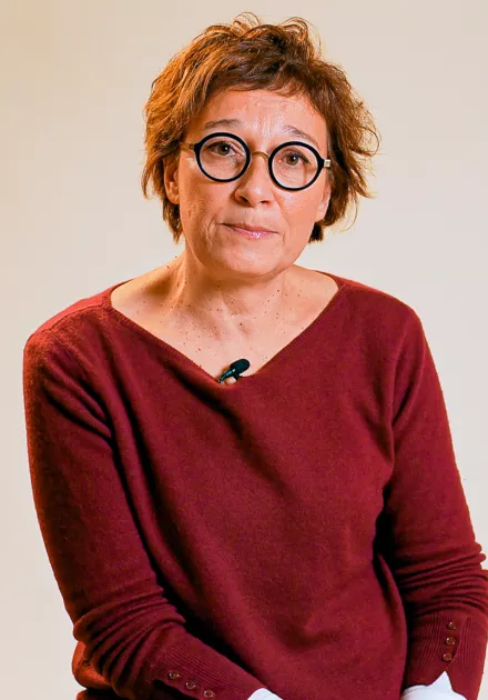 L'intervenante est assise sur une chaise en regardant la caméra